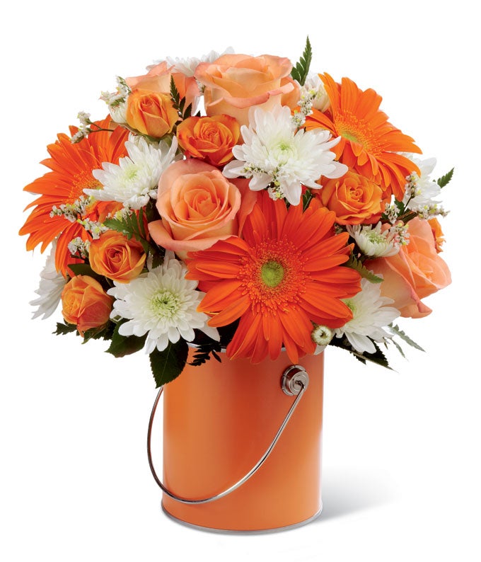 A bouquet of Orange Gerbera Daisies, Orange Roses, White Chrysanthemums and Lush Greens on a Decorative Orange Vase