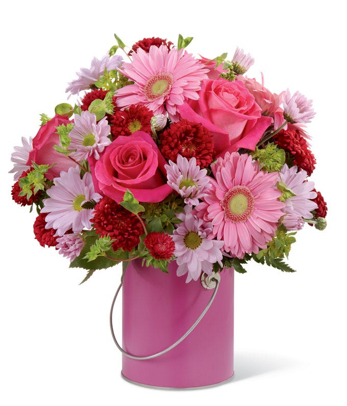 Pink Gerber daisies, pink roses, purple daisies all in a pink paint vase