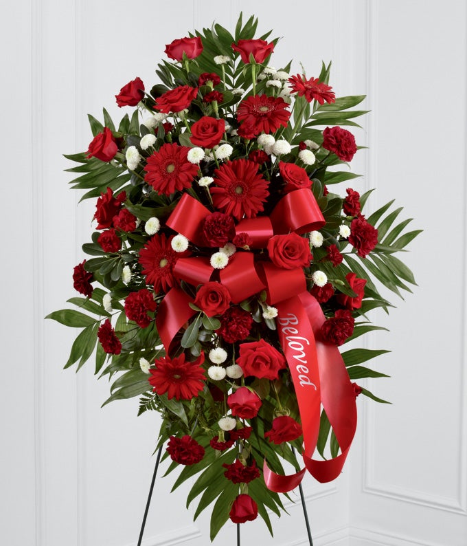 funeral spray with red daisies