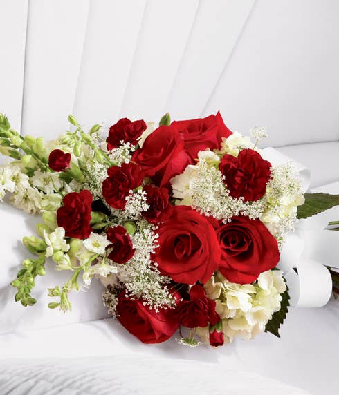 Red roses and white hydrangea casket adornment