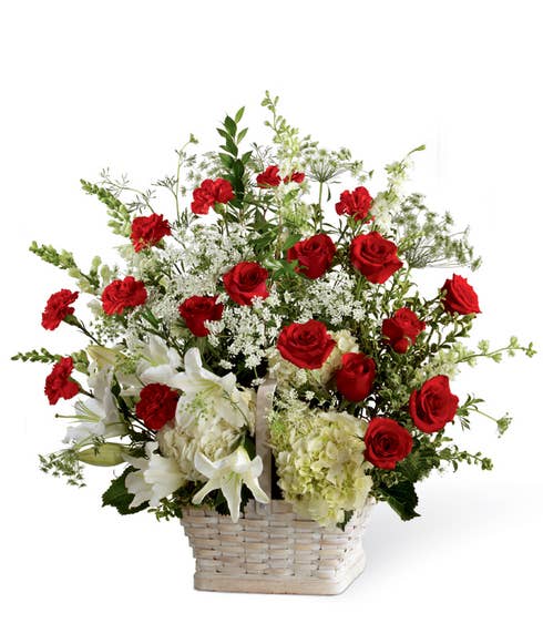 Basket sympathy arrangement with red roses, carnations and white hydrangea
