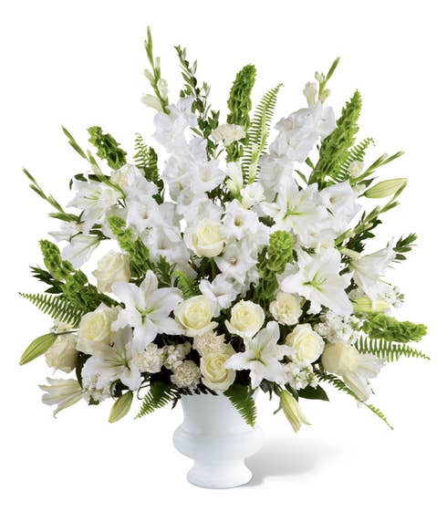 Beautiful white roses, bells of ireland and oriental lilies in sympathy arrangement 
