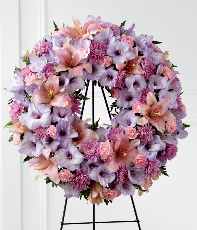 Round Flower arrangement including Periwinkle Gladiolus, Pink Asiatic Lilies, Lavender Chrysanthemums, and Light-Pink Mini Carnations with Stand Included