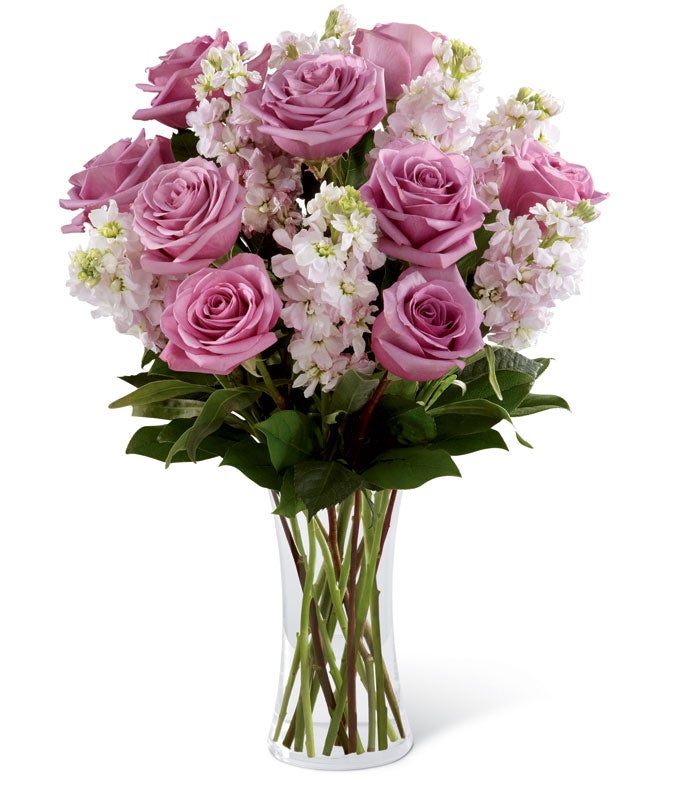 A Bouquet of Purple Roses and Pink Stock in a Keepsake Glass Vase