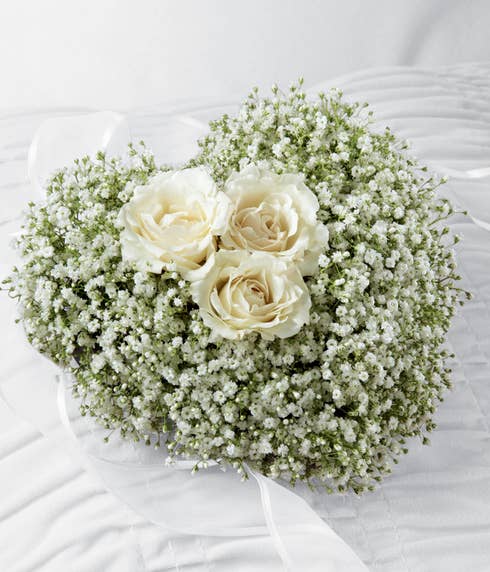 Baby's breath and white spray roses in a heart-shaped arrangement