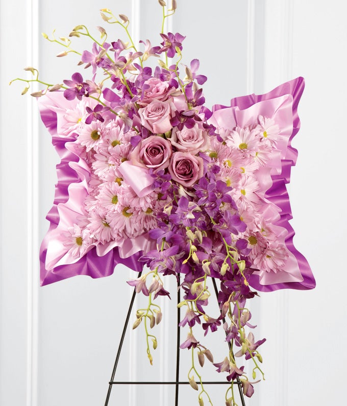 A Pillow-Shaped Bouquet of Lavender Roses, Purple Dendrobium Orchids and Pale Daisies Displayed on Wire Easel