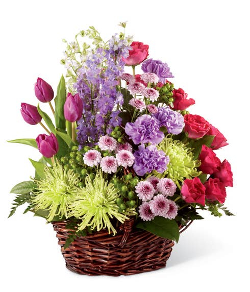 Sympathy flower arrangement with purple tulips, carnations and red roses