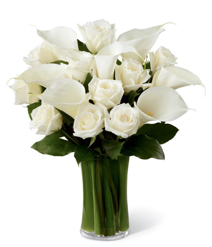 A Bouquet of White Roses, White Calla Lilies and Fresh Greens in a Gathering Vase