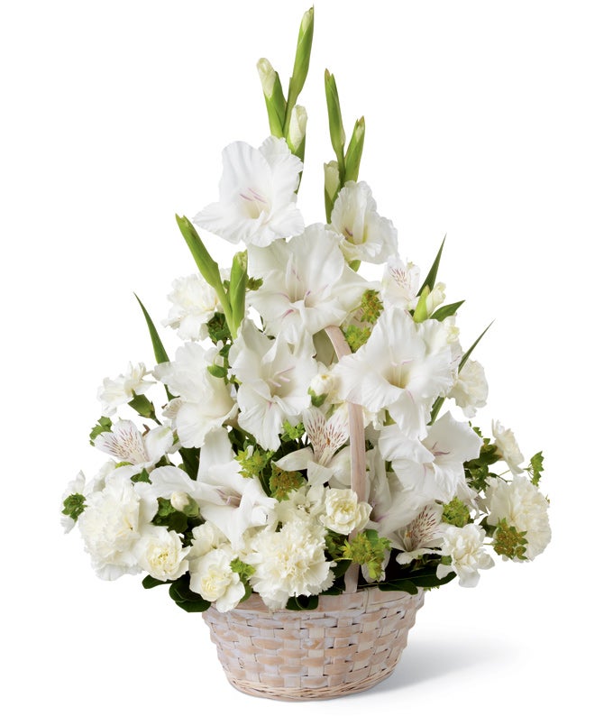 A Bouquet of  White Gladiolus, Cream Peruvian Lilies, Alabaster Carnations, Ivory Mini Carnations, and Lush Greens in a Keepsake Whitewash Basket