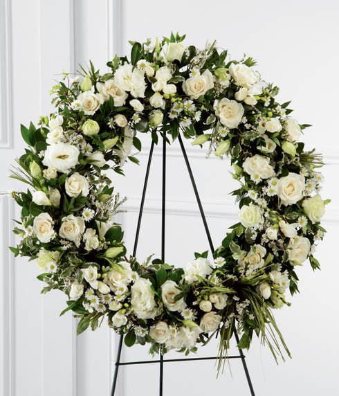 Sympathy white flower wreath standing spray with roses, lisianthus, and freesia