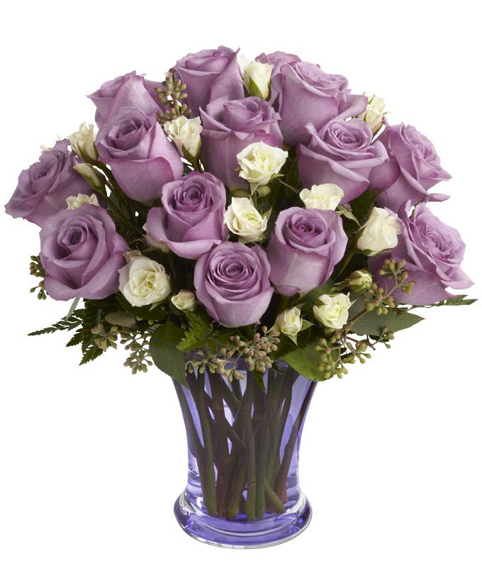 A Bouquet of Purple Roses and White Spray Roses in a Colorful Glass Vase