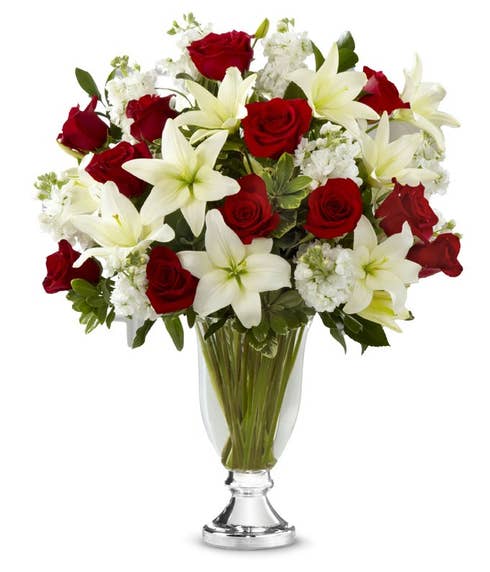 Stunning red roses and white lilies delivered in a beautiful glass vase for the holidays