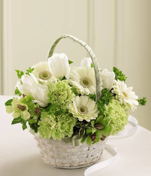 A white flower girl basket with white tulips
