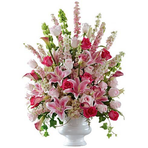 Sympathy flower arrangement with pink roses, bells of ireland and hydrangea