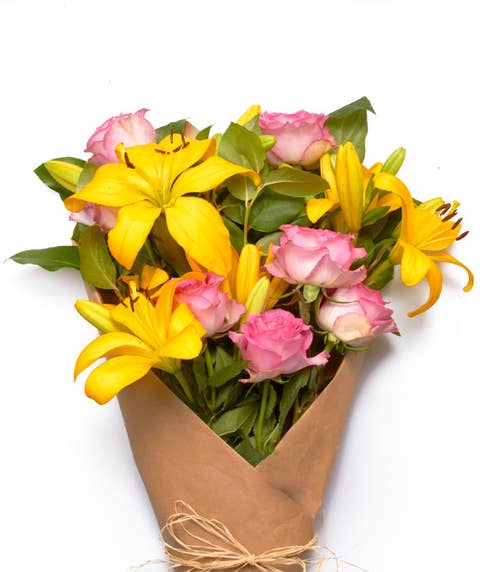 Wrapped yellow lilies and hot pink rose bouquet