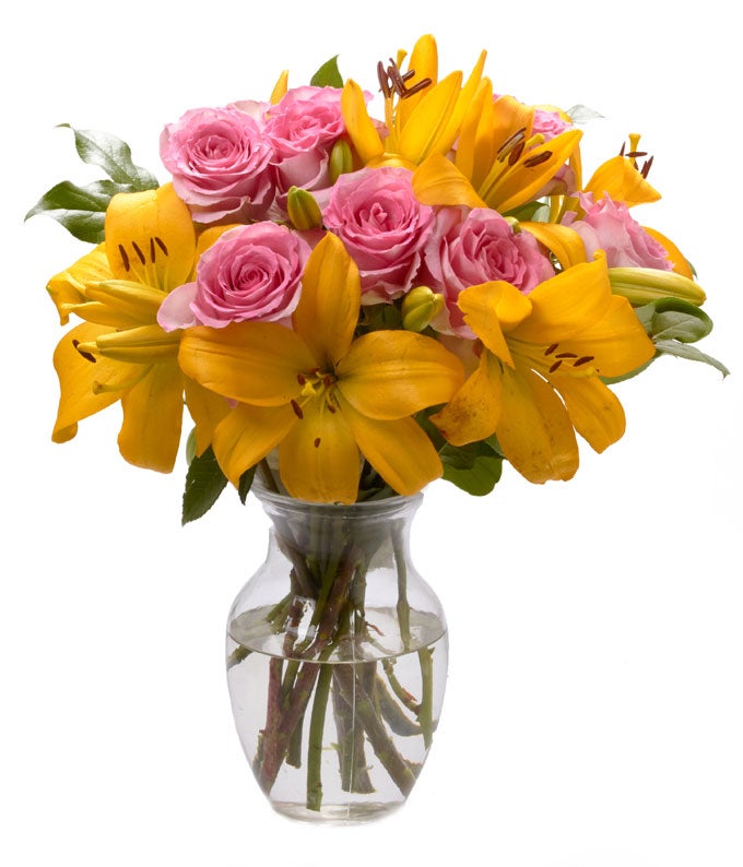 A Bouquet of Yellow Asiatic Lilies, Pink Spray Roses and Fresh Greens in a Clear Glass Vase