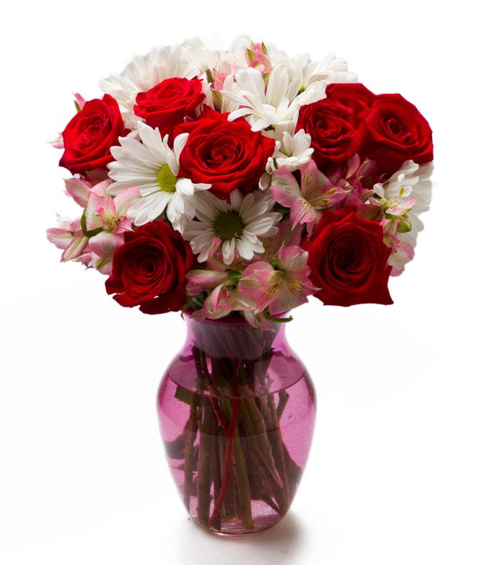 red rose white daisy bouquet with pink alstroemeria in a pink glass vase
