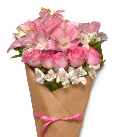 Paper wrapped pink rose, pink lily, and white alstroemeria bouquet 