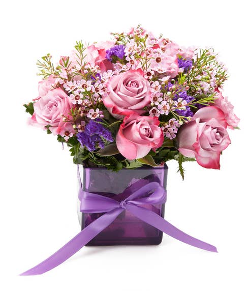 Purple bicolor rose bouquet with violets a lavender flowers in purple vase