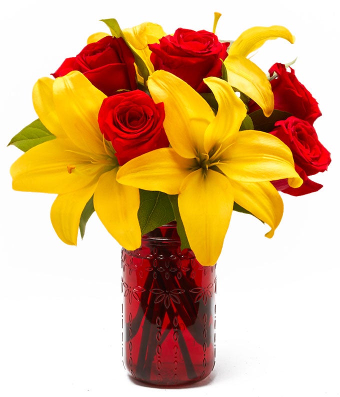 A Bouquet of Yellow Asiatic Lilies, Red Roses and Salal Tip in a Red Mason Jar Vase