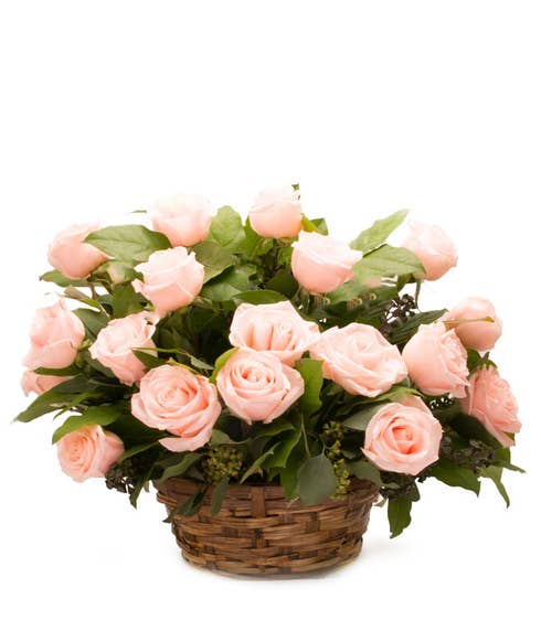 Light pink rose basket flower arrangement with woven basket and card message