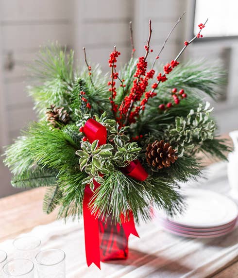 Mixed evergreen bouquet with red christmas flowers and red holiday berries