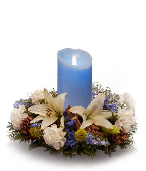 Blue candle and flower centerpiece with white lily and blue delphinium