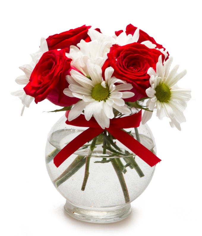 A bouquet of flowers including Red Roses and White Daisies in a Mini Glass Vase