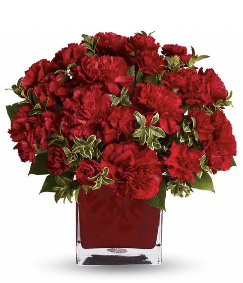 Red flower bouquet of romantic red carnations with red square glass vase