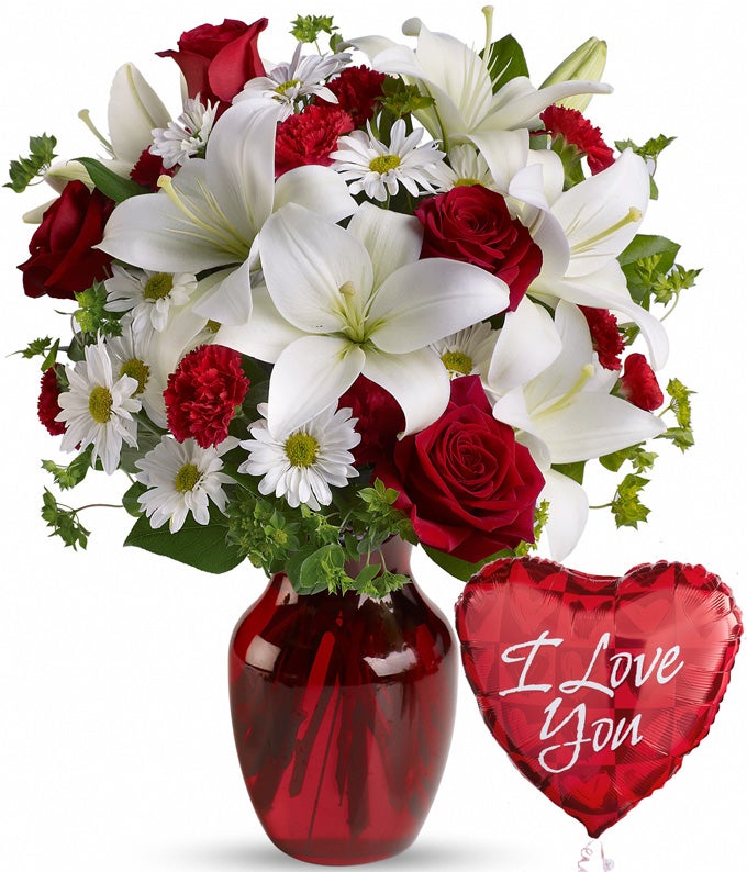 A Bouquet of  Red Roses, White Asiatic Lilies, White Daisy Spray Mums, and Red Mini Carnations in a Red Glass Vase with 1 Love-Themed Mylar Balloon