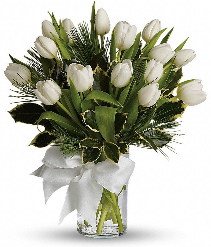 White tulip bouquet with white tulips inside of a clear glass vase with white bow
