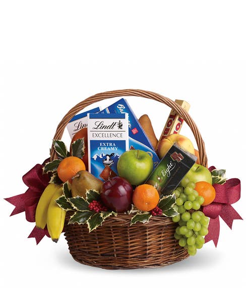 Chocolate and fruits gifts basket with chocolate bars, bananas, grapes and oranges