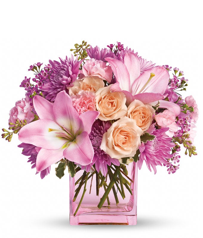 A Bouquet of  Peach Roses, Pink Asiatic Lilies, Blush Carnations, and Lavender Cushion Mums in a Light-Pink Glass Cube Vase