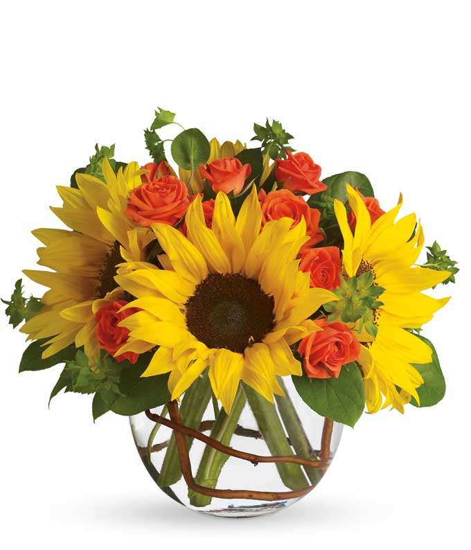 A bouquet of Sunflowers, Orange Spray Roses (Included in Deluxe and Premium sizes only), Bupleurum, Curly Willow, Salal in a Glass Vase