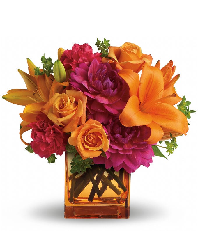 A Bouquet of  Hot Pink Dahlias, Orange Roses, Orange Asiatic Lilies, and Hot Pink Carnations in an Orange Glass Cube Vase