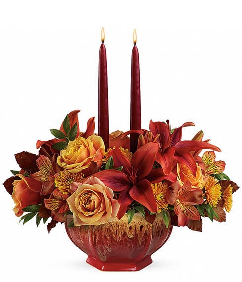 Peach roses, Burgundy lilies and candles create a rustic centerpiece