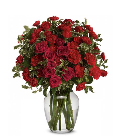 Miniature red roses and red carnations mixed flower bouquet in clear vase