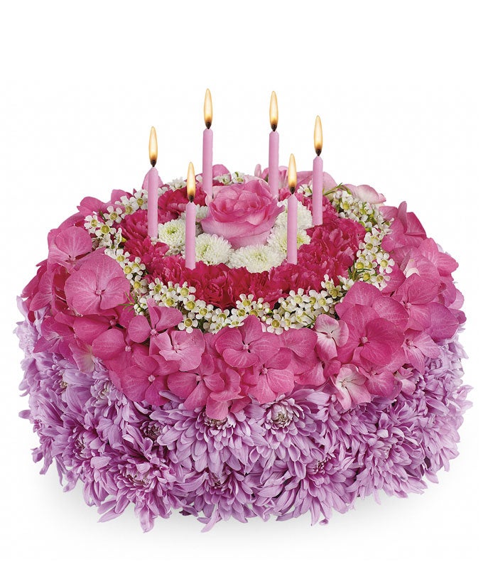 A Bouquet of Pink Roses, Pink Hydrangea, White Waxflower, Lavender Cushion Spray Chrysanthemums, White Button Spray Chrysanthemums and Hot Pink Carnation Minis shaped as 1 whole cake with 6 Candles