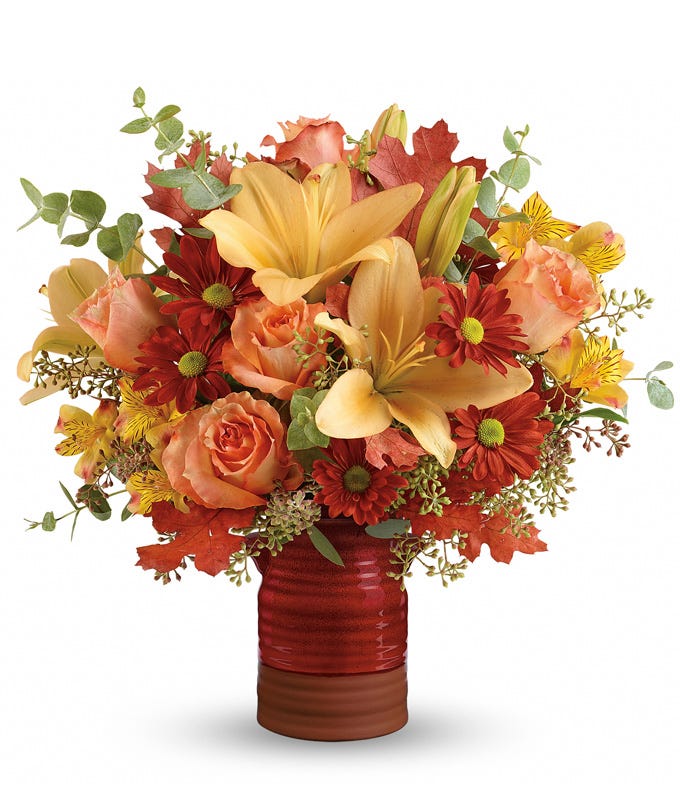 Orange mason jar flowers arrangement with peach lilies, peach roses and vase