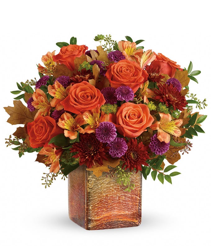 Orange roses, orange alstroemeria and purple mums in a square orange vase