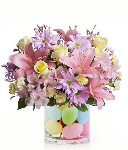 Pink lily and lavender daisy mixed Easter flowers bouquet with plastic Easter eggs