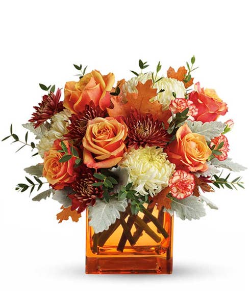 Fall flower bouquet with orange roses, red chrysanthemums, and yellow oak leaves