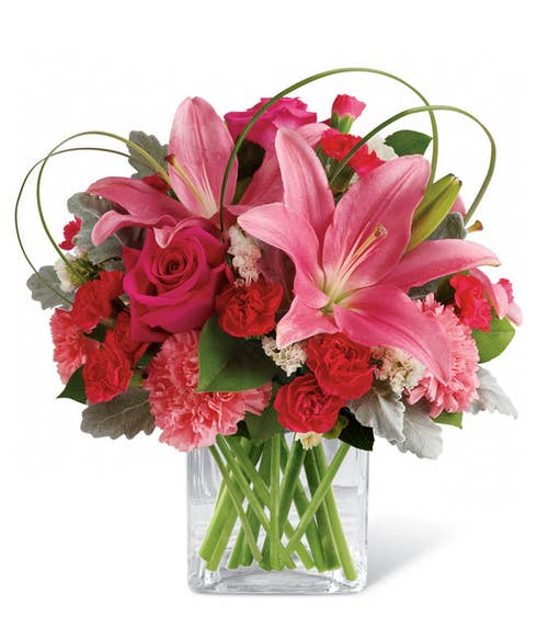 Pink lilies, red roses and carnations in a square heart vase