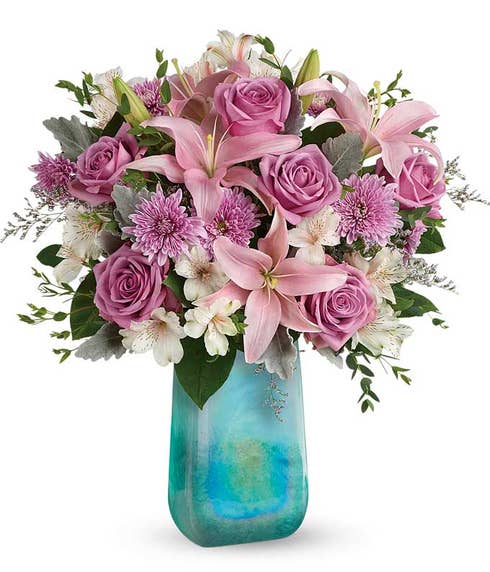 Pink asiatic lily, purple roses and lavender chrysanthemums bouquet in blue vase