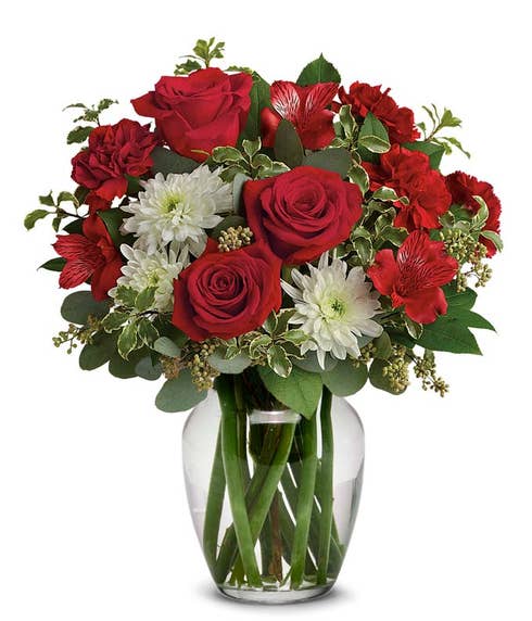 red roses, alstroemeria and carnations with pops of white chrysanthemums in clear container