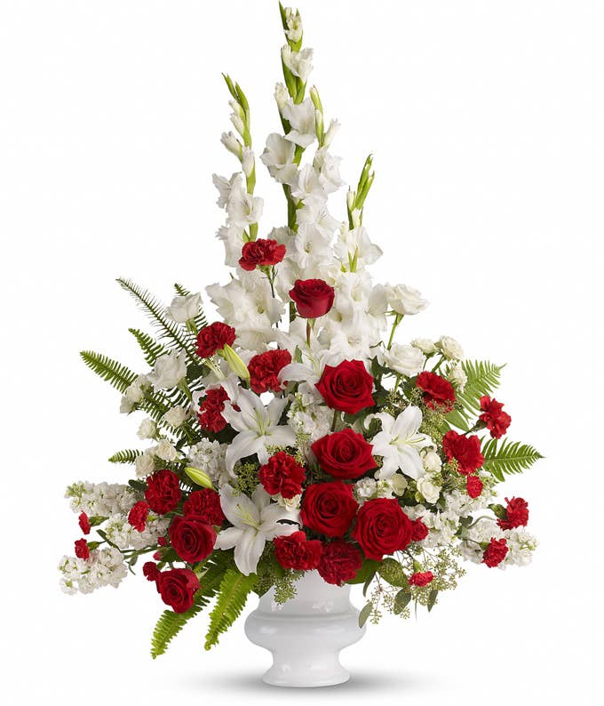 A Bouquet of Red Carnations, Red Roses, White Chrysanthemums, White Snapdragons, White Stock, Blue Delphinium and Blue Hydrangea in a White Urn Vase