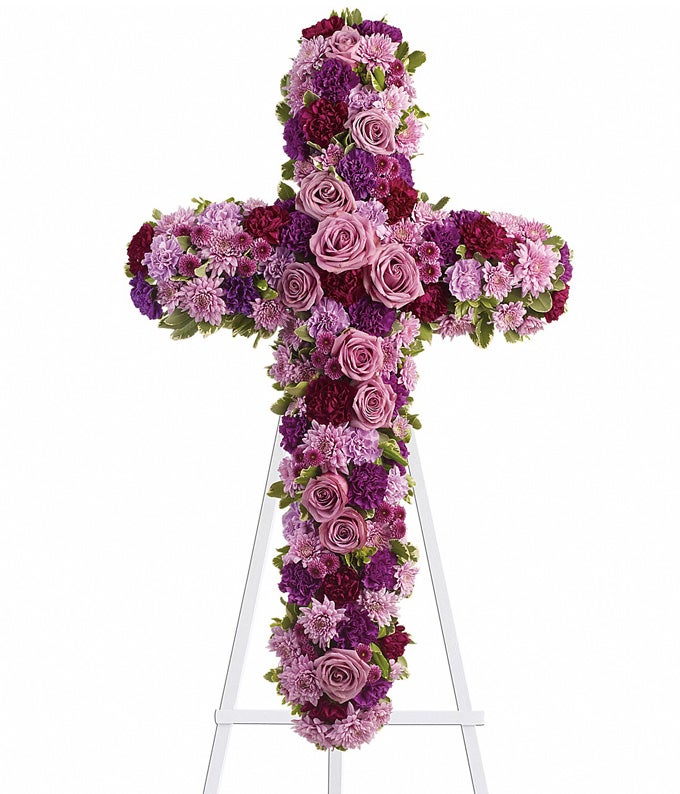 Cross Flower arrangement including  Lilac Carnations, Light Purple Roses, Lavender Chrysanthemums, and Purple Chrysanthemums with Stand Included