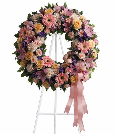 Pastel circle flower wreath standing funeral spray delivery at Send Flowers