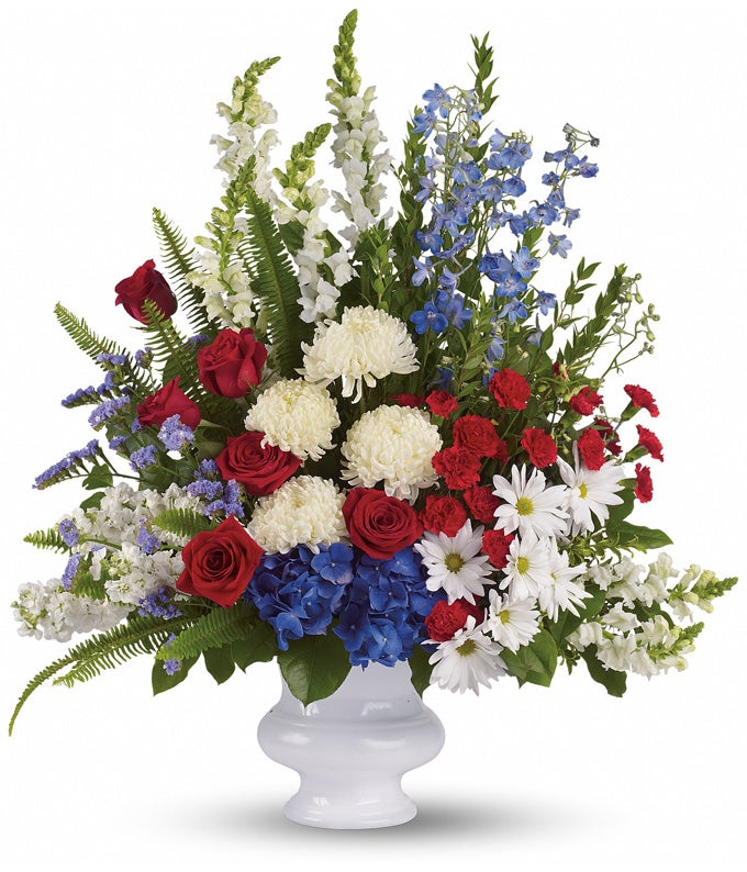 A Bouquet of Red Carnations, Red Roses, White Chrysanthemums, White Snapdragons, White Stock, Blue Delphinium, and Blue Hydrangea in a White Urn Vase