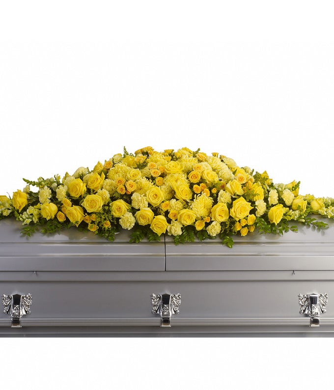 Casket Spray Including Yellow Roses, Yellow Carnations, Yellow Snapdragons, Yellow Chrysanthemums, Yellow Solidago, Huckleberry and Leatherleaf Fern